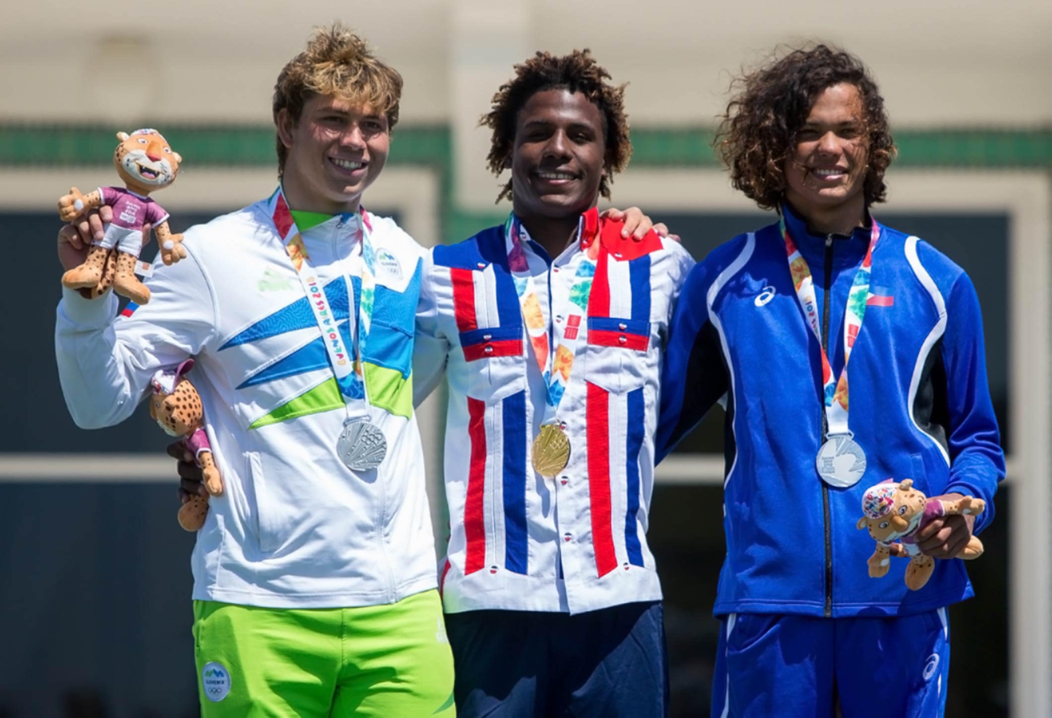 Men’s kiteboard champion Deury Corniel (DOM) is flanked by joint silver medallists Toni Vodisek (SLO, left) and Filipino Christian Tio (Gabriel Heusi for OIS/IOC)
