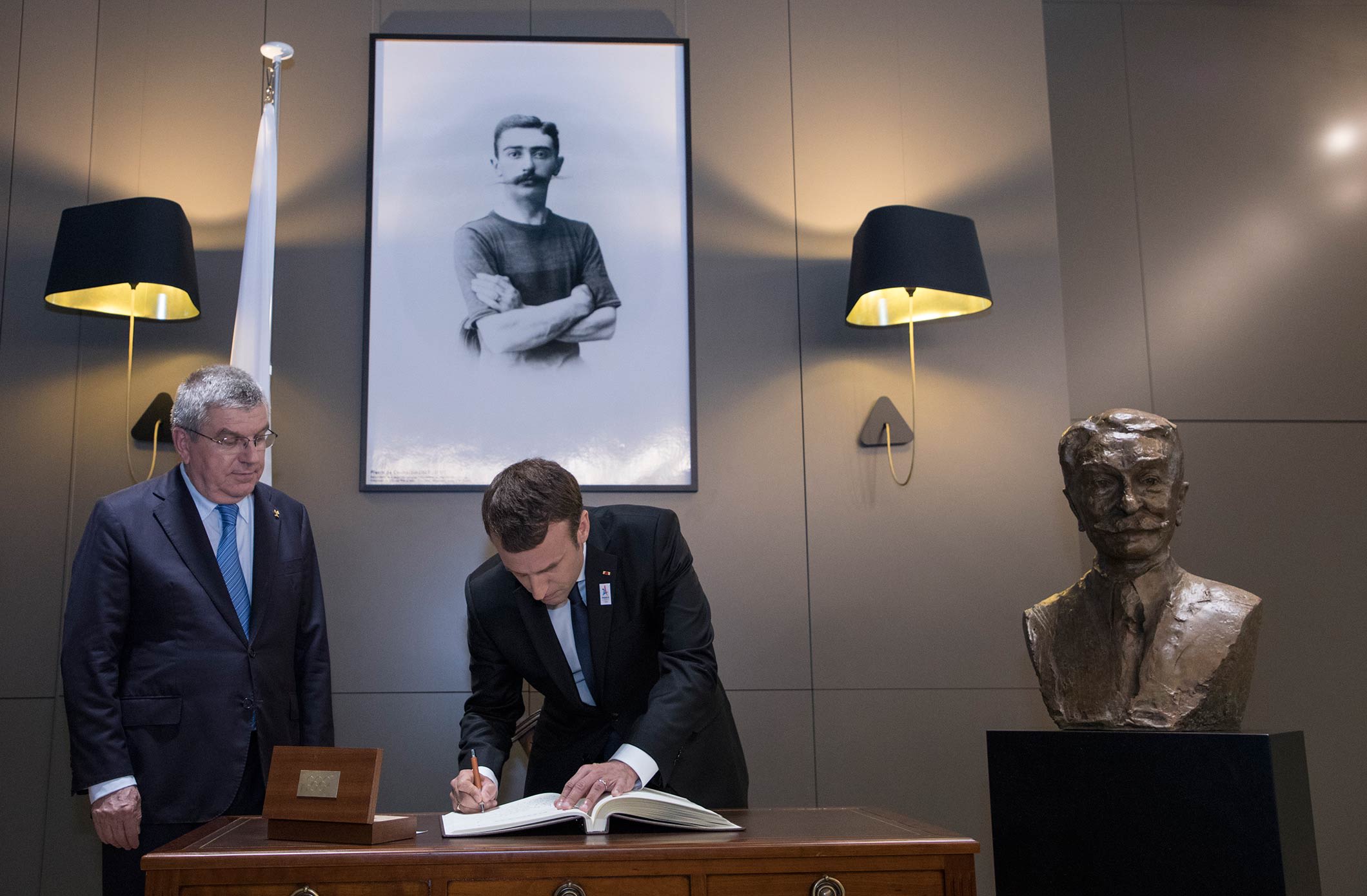 President of the French Republic Emmanuel Macron signing the Golden book at the Olympic Museum 