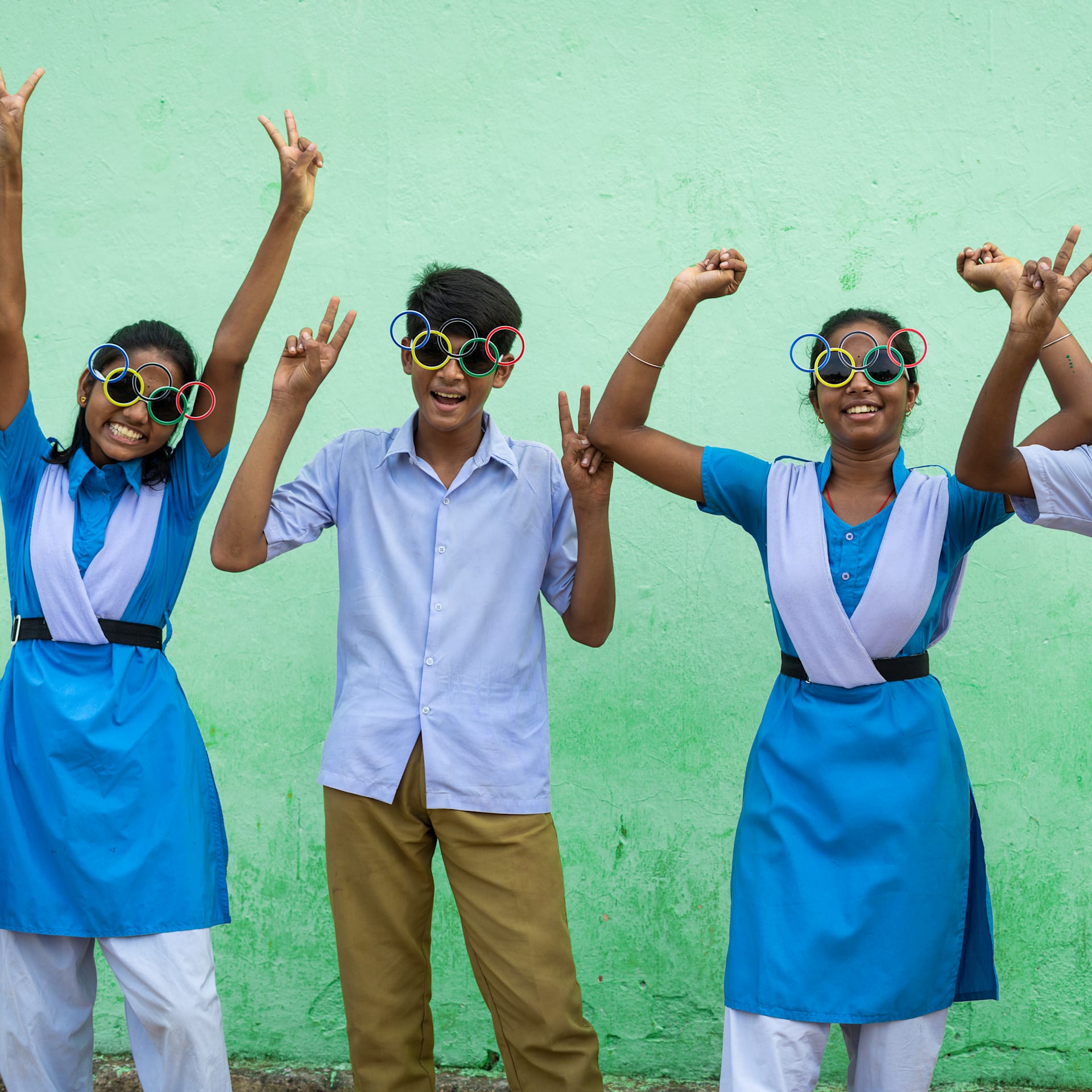 Indian children smiling and wearing olympic sunglasses