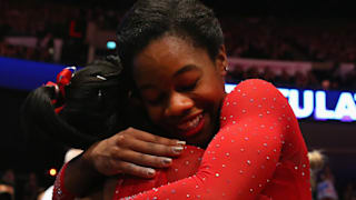 Simone Biles and Gabby Douglas embrace after taking gold and silver in the all-around at the 2015 Worlds