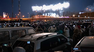 People close to the National Stadium watch fireworks at the Opening Ceremony of Beijing 2022