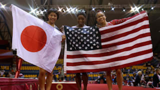 Mai Murakami (left), Simone Biles (center) and Morgan Hurd (right) pose with their flags after taking the women's all-around medals at the 2018 Worlds