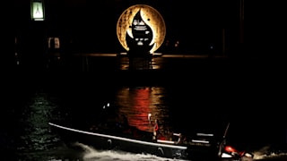 Rafael Nadal carries the torch on a boat