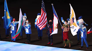 Flag bearer Nathan Crumpton of Team American Samoa (2nd right) walks in the Athletes Parade 