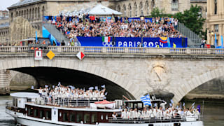 Athletes of Team Greece wave flags on the team boat