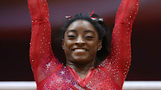 Simone Biles smiles after dismounting the uneven bars during the team final at the 2018 Worlds