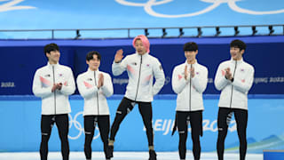 Kwak Yoongy dances on the podium during the men's 5000m relay victory ceremony