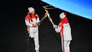 Torchbearers carry the Olympic flame during the Opening Ceremony of the Beijing 2022 Winter Paralympics