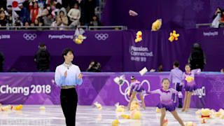 Fans throw gifts on to the ice and hold Japanese flags for Yuzuru Hanyu after his routine during the 2018 PyeongChang Winter Olympic Games.