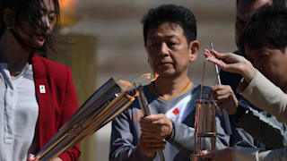 Former Japanese swimmer Imoto Naoko holds the Olympic torch during the Flame Handover Ceremony for the Tokyo 2020 Summer Olympics (Photo by Aris Messinis - Pool/Getty Images Europe)