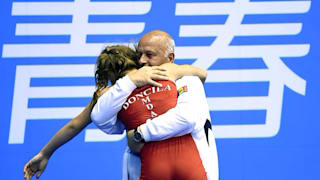 Tatiana Doncila hugs her coach after winning the Women’s Freestyle 46kg Bronze Match of Wrestling