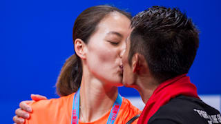 Lin Dan kisses his wife and double world champion Xie Xingfang after winning his fifth world men's singles title