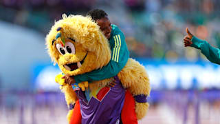 Silver medallist Mosinet Geremew of Ethiopia celebrates with the mascot, Legend, during the medal ceremony for the Men's Marathon at the World Athletics Championships Oregon22. (Photo by Steph Chambers/Getty Images)