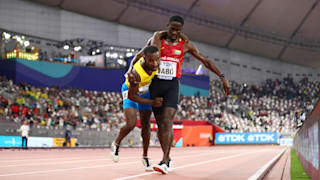 Braima Suncar Dabo helps Jonathan Busby in the home straight in their 5000m heat in Doha