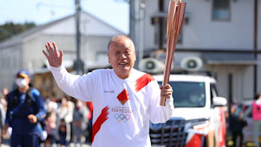 Tokyo 1964 torchbearer carries Olympic flame again