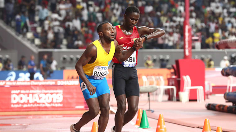 Braima Dabo helps Jonathan Busby during their 5000m heats at the 2019 World Championships.