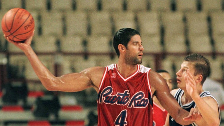 Puerto Rico's center Jose Ortiz (L) passes the ball as Igor Koudelin tries to block at the 13th world basketball championship