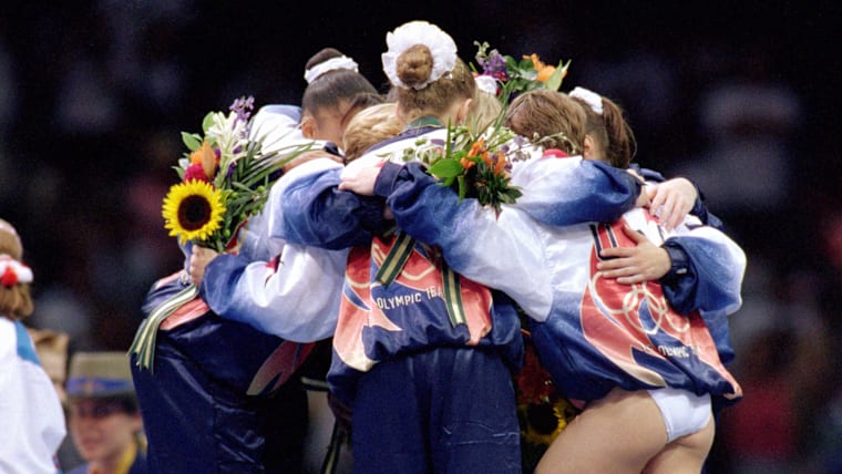 The Magnificent Seven huddle after the Atlanta 1996 medal ceremony.