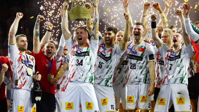SC Magdeburg's Michael Damgaard Nielsen lifts the trophy as his teammates cheer and celebrate