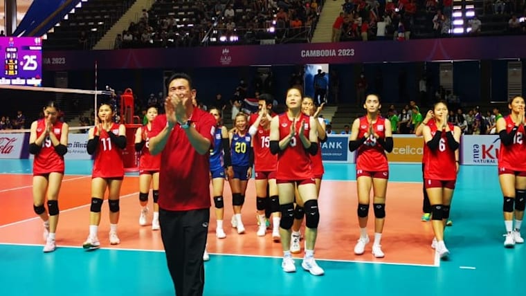 Thailand players and coach celebrate after beating Myanmar in straight sets at the Southeast Asian Games in Cambodia.