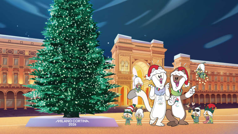 Le mascotte di Milano Cortina 2026 di fronte all'Albero dei Giochi a Milano