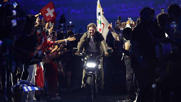 L'acteur et producteur de cinéma américain Tom Cruise roule sur une moto avec le drapeau olympique lors de la cérémonie de cl?ture des Jeux Olympiques de Paris 2024 au Stade de France le 11 ao?t 2024 à Paris, France