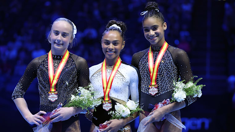 Second place all around winner Claire Pease, all around champion Hezly Rivera and third place all around winner Charleigh Bullock pose