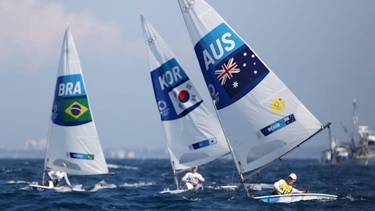 Three athletes competing in the men's laser class competition at the Tokyo 2020 Olympic Games.