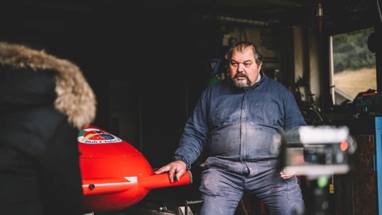 Foto di Diego Menardi seduto, con a fianco un bob.