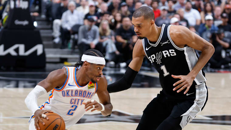 Shai Gilgeous-Alexander #2 of the Oklahoma City Thunder drives against Victor Wembanyama #1 of the San Antonio Spurs