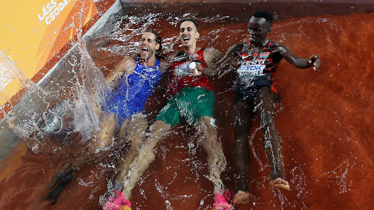 Men's high jump gold medalist Gianmarco Tamberi of Italy, men's 3000m steeplechase gold medalist Soufiane El Bakkali of Morocco and bronze medalist Abraham Kibiwot of Kenya jump into the water on track during the World Athletics Championships Budapest 2023