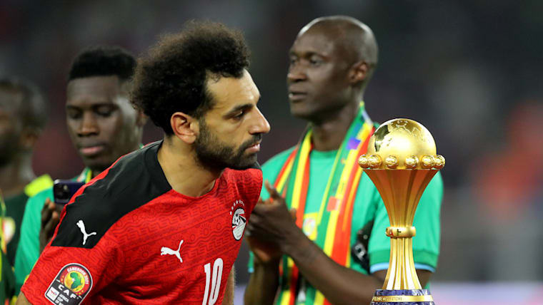 Salah walks past the Africa Cup of Nations trophy as Senegal players applaud