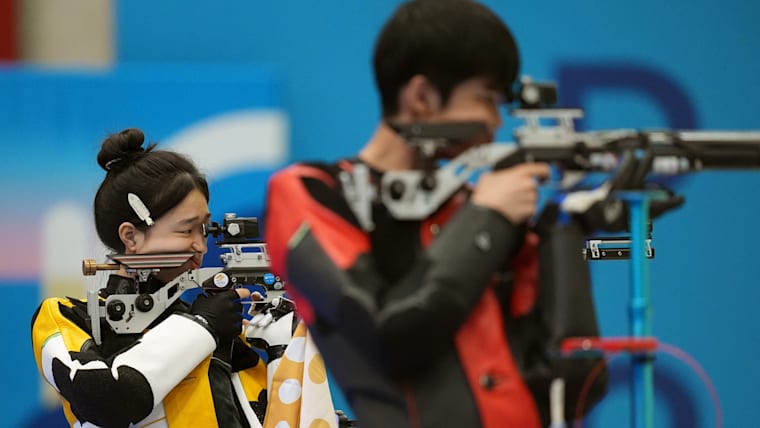 Yuting Huang (L) and Lihao Sheng compete for the 10m Air Rifle Mixed Team gold medal