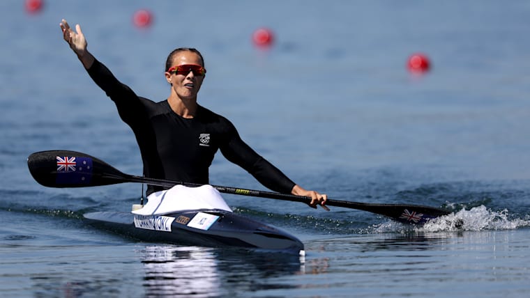 Carrington raises her right arm in the air to celebrate her K1 500m gold at Paris 2024