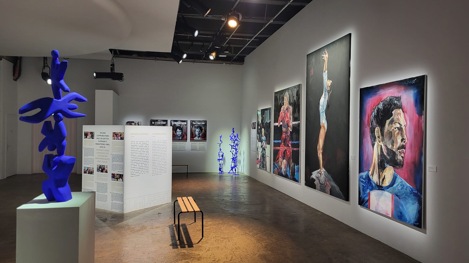 Artworks by Olympians on view at Palais de Tokyo (Clubhouse) during the Olympic Games Paris 2024. At right: Oil paintings by Luc ABALO. At left, sculpture by Clementine STONEY MACONACHIE. In the back, oil paintings by Brooklyn MCDOUGALL.