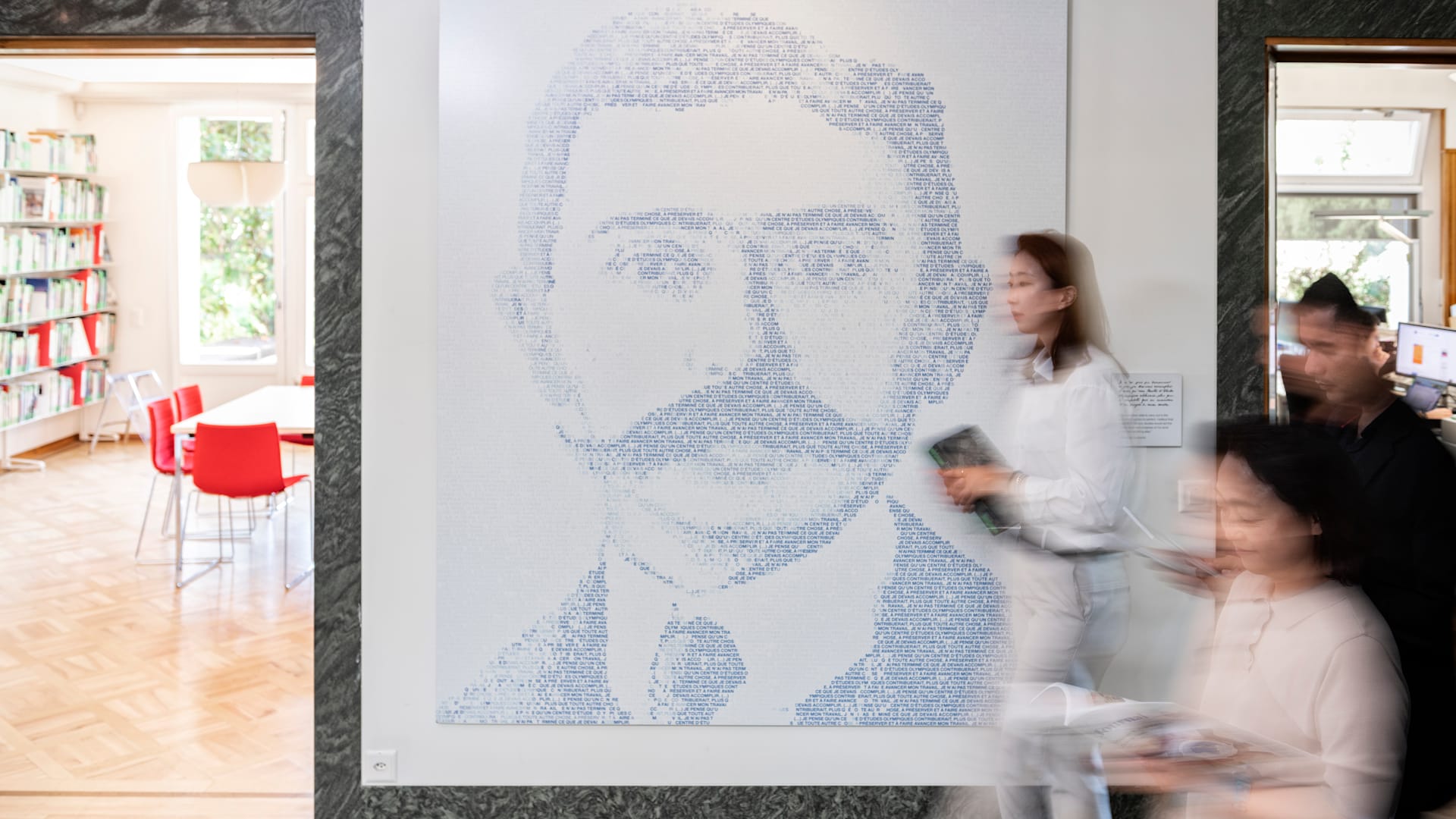 People walking by a a big poster in the Olympic Studies Centre