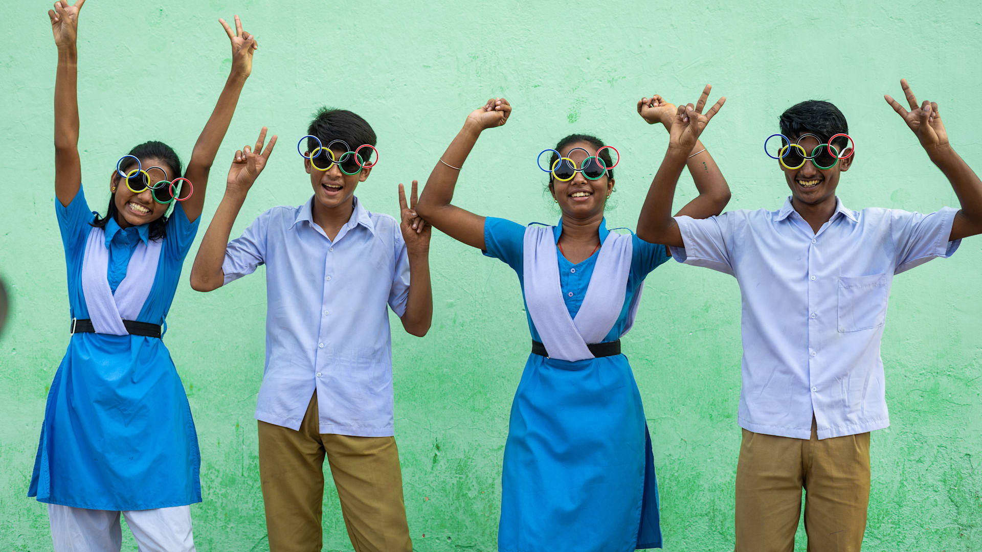 Indian children smiling and wearing olympic sunglasses