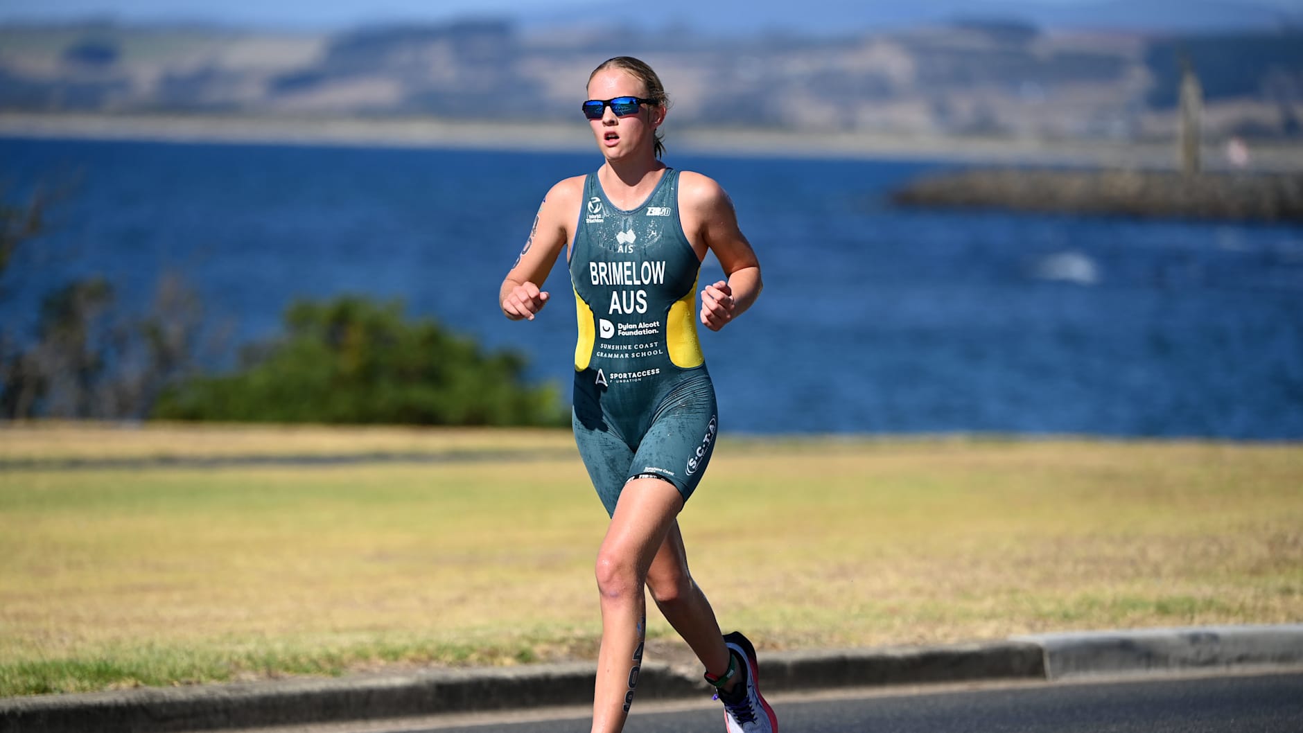 Grace Brimelow running during the 2025 Devonport Triathlon. She is wearing dark racing glasses and an Australian Paralympics uniform. 
