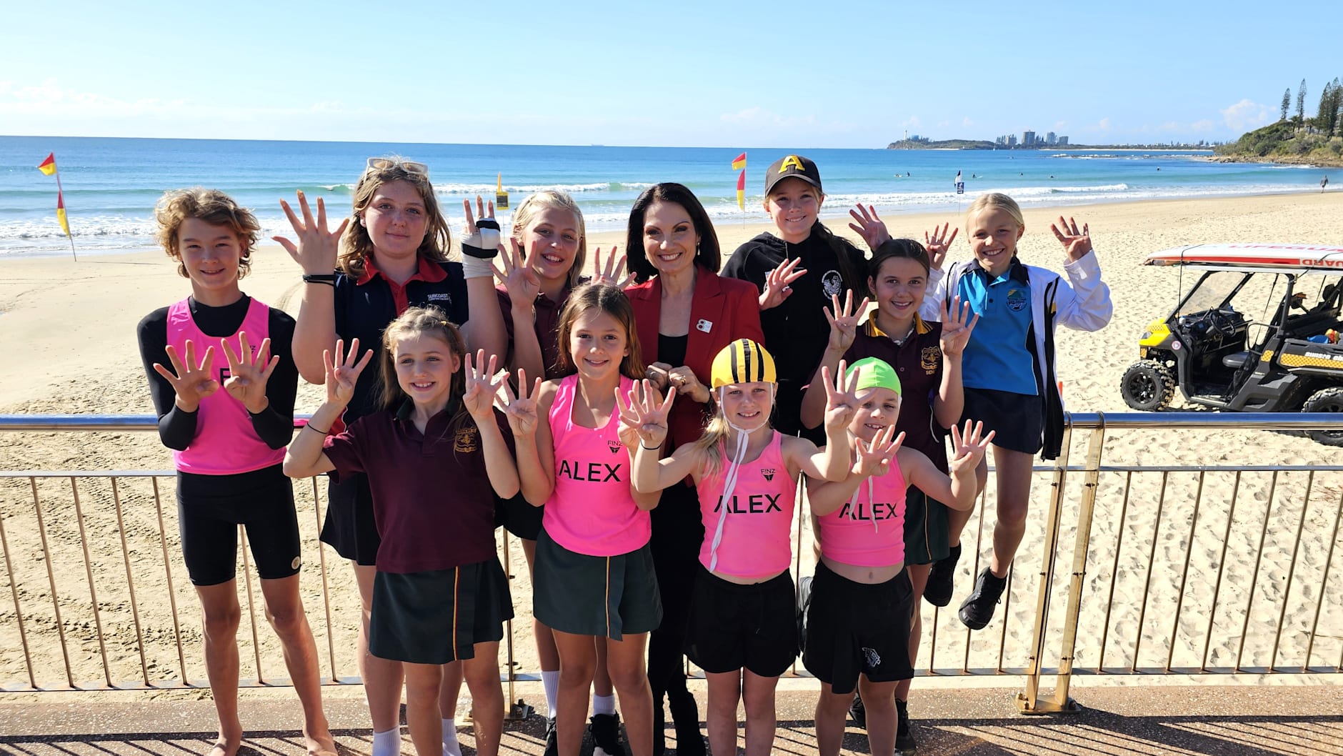 Local nippers celebrate 8 Years to Go by holding up the number eight with their fingers at the Sunshine Coast