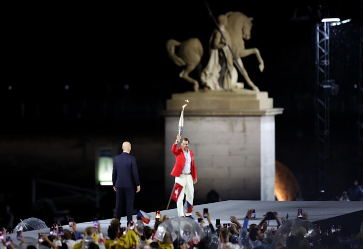 Zinedine Zidane looks on as Rafael Nadal of Team Spain carries the flame during the Opening Ceremony of the Olympic Games Paris 2024