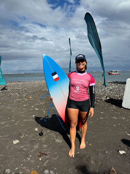 Johanne Defay (FRA), sporting a hat to cover up some fresh stitches on her head after a bad wipeout in Round 1, is all smiles after winning her Round 2 heat