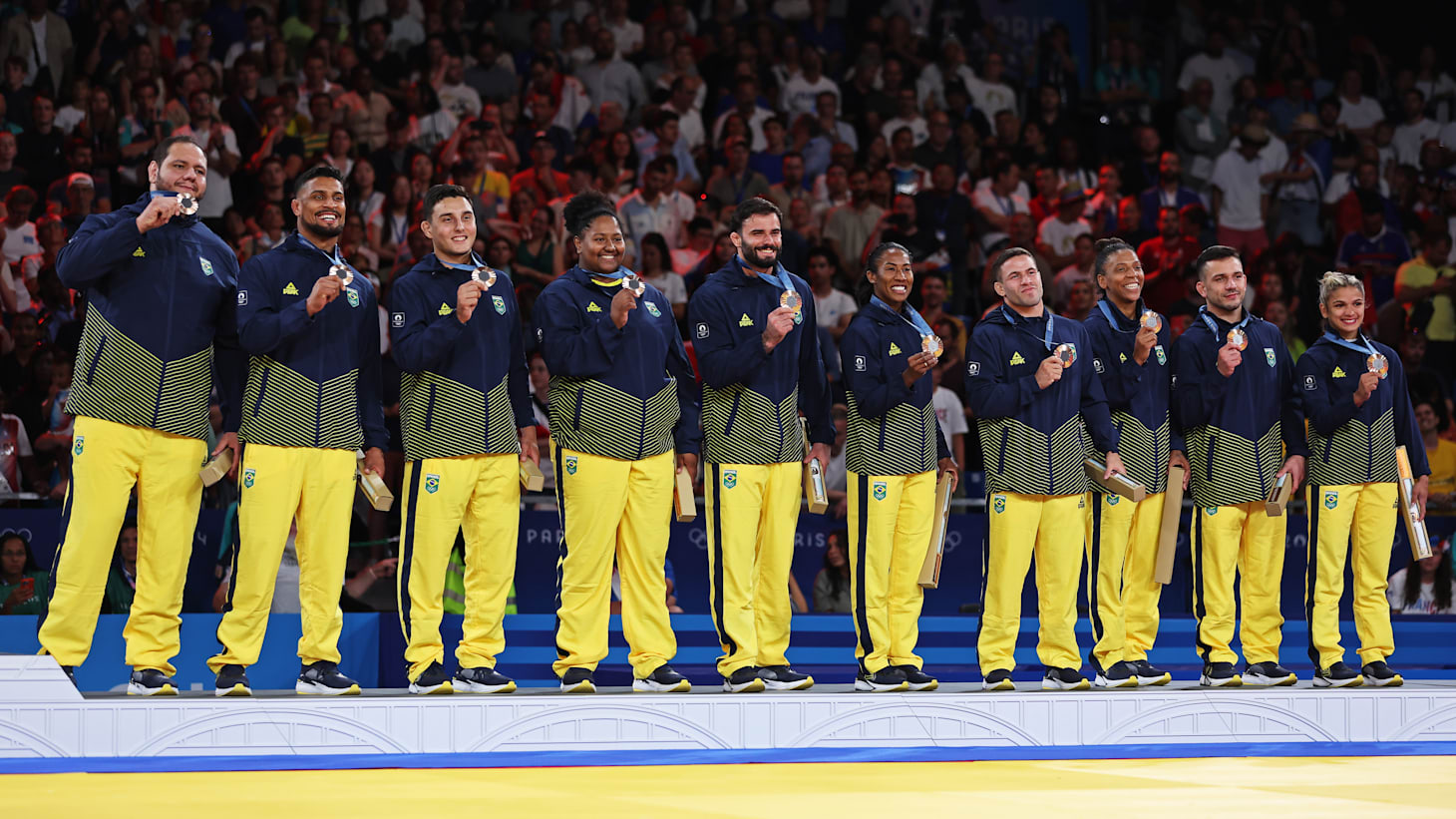 Bronze medalists Team Brazil celebrates on the podium at the Judo Mixed Team medal ceremony on day eight of the Olympic Games Paris 2024 at Champs-de-Mars Arena on August 03, 2024 in Paris, France.