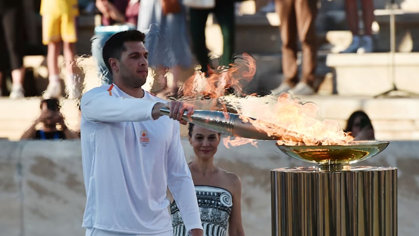Ioannis Fountoulis lights the cauldron during the Olympic flame handover ceremony for the Paris 2024 Summer Olympics