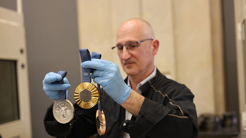 Eric Matte, jefe de producción industrial de la Casa de la Moneda de París, sostiene las medallas olímpicas de París 2024