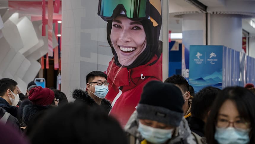 Customers at an authorized Beijing 2022 Winter Olympics store crowd under a photo of Eileen Gu