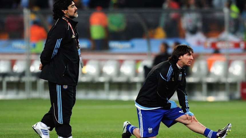 Lionel Messi stretches in training at the 2010 World Cup watched by head coach Diego Maradona