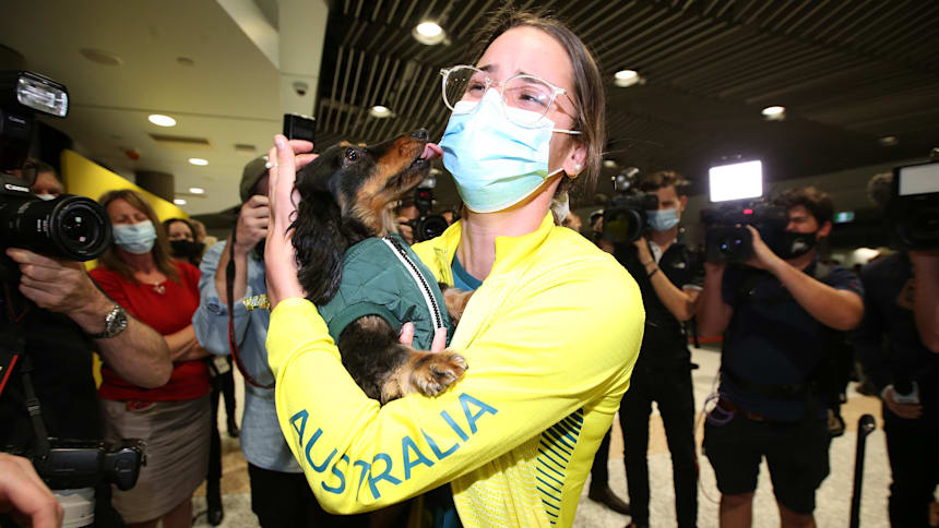 Olympic Champion Kaylee McKeown hugs her dog Otis as she arrives at home