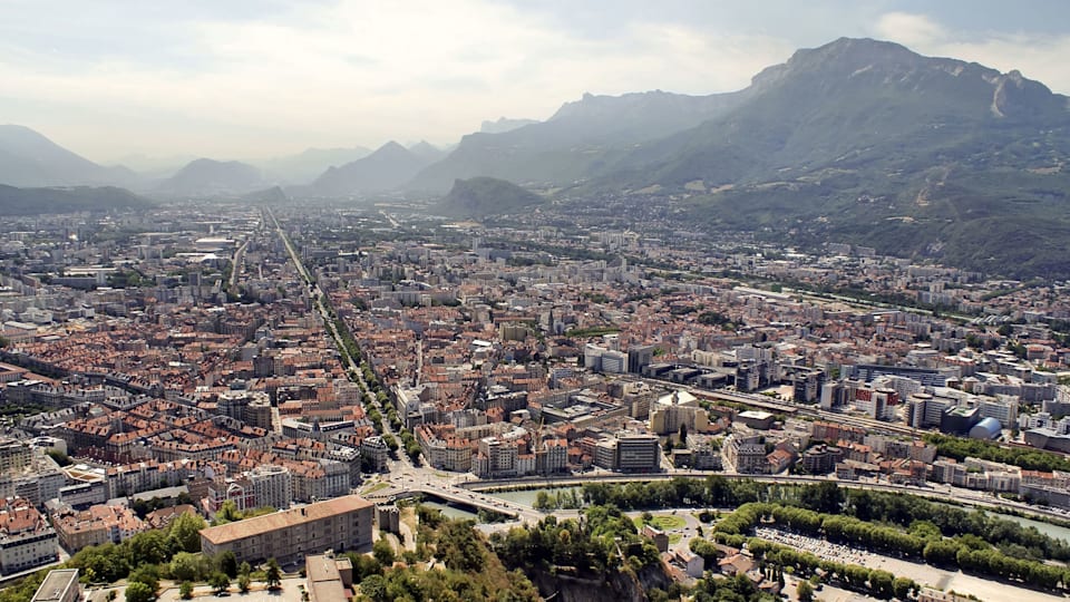 Vue aérienne de l'agglomération de Grenoble. Les Jeux Olympiques d'hiver de 1968 ont contribué au développement des routes départementales et des systèmes de transport ferroviaire et aérien de l'Isère.