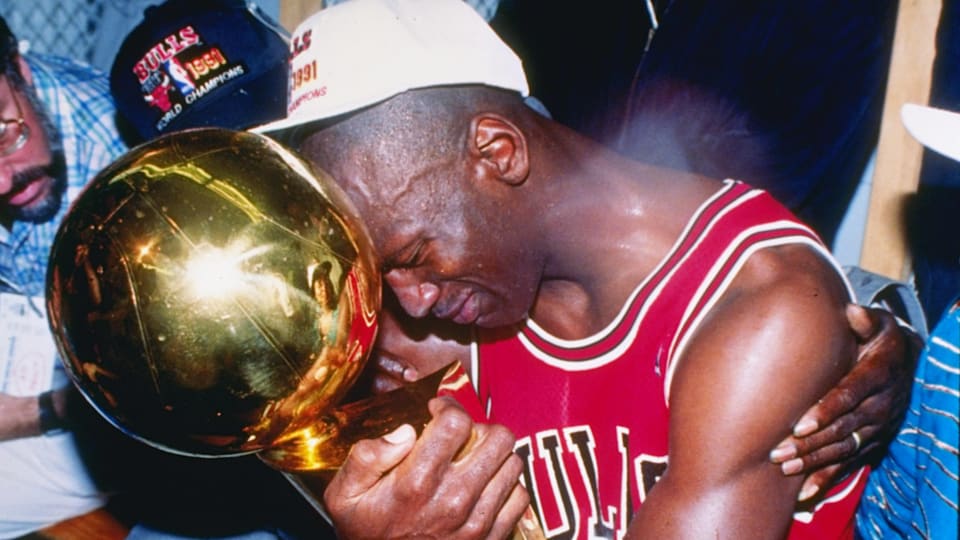 Michael Jordan de Chicago Bulls se sienta junto a su esposa Juanita y su padre James mientras abrazan el trofeo del Campeonato de la NBA tras vencer a Lakers en las Finales NBA del 1991 (Foto de Ken Levine/Getty Images)