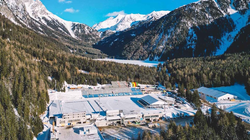 Aerial view of Anterselva surrounded by trees and snow-capped mountains